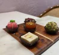 Assorted luxury mithai on a wooden board
